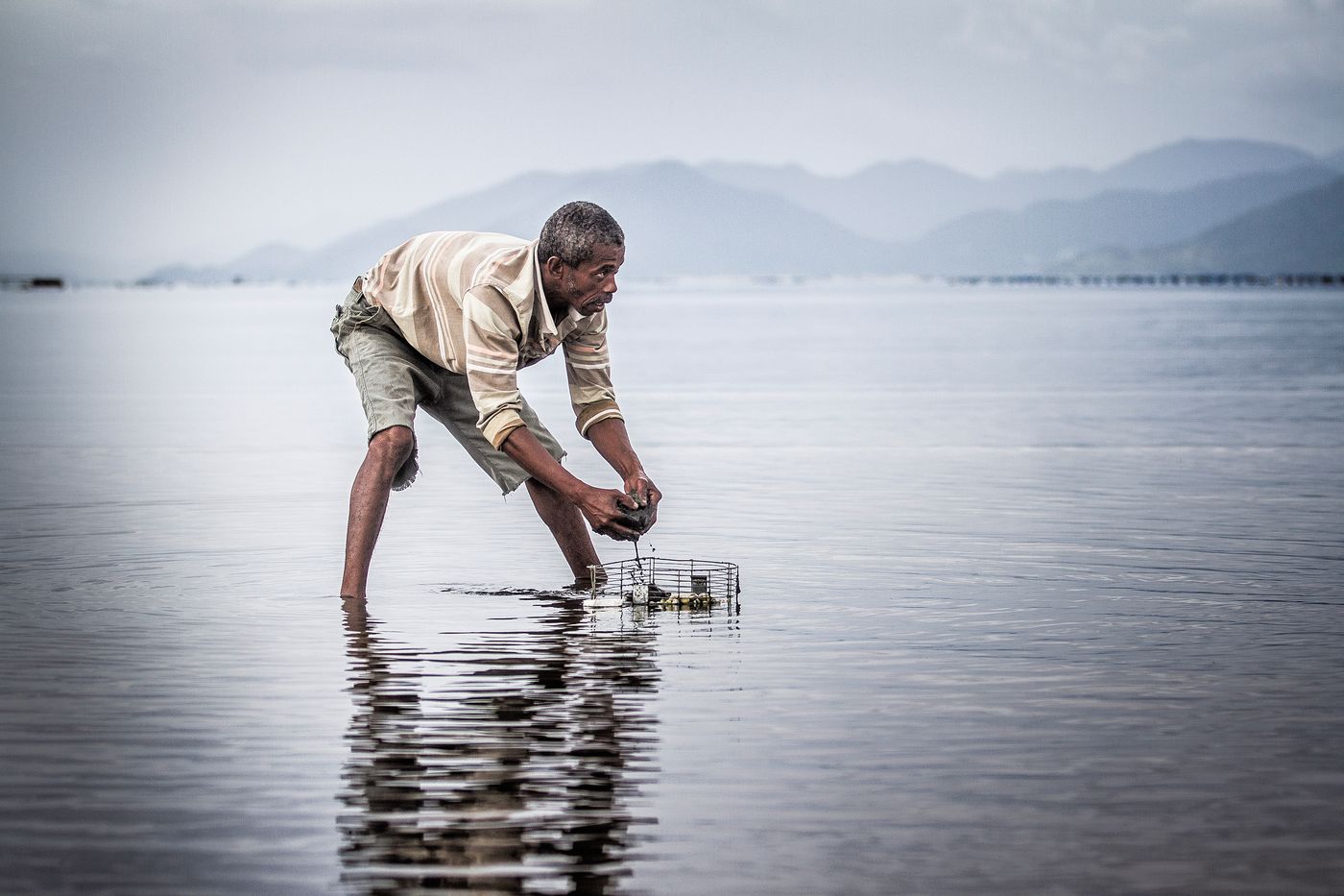 Ednilson da Silva, catador de berbigão na praia da Tapera, sul da ilha. Florianópolis, 30 de abril de 2014. Fotografia de Flávio Tin integrante da série coletiva premiada.